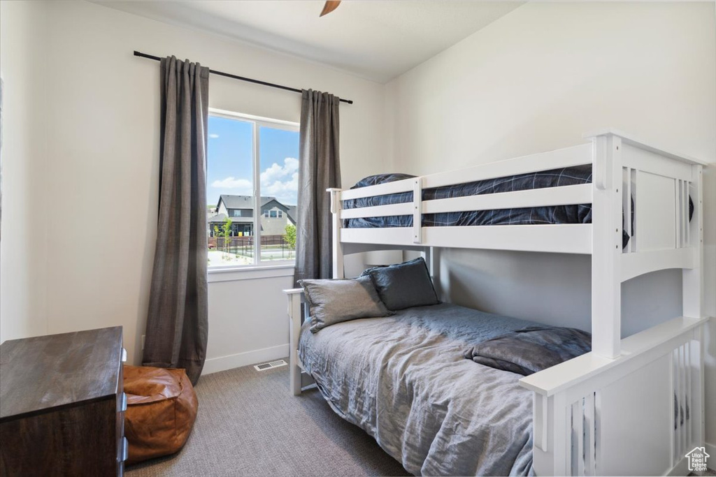 Carpeted bedroom with baseboards and a ceiling fan