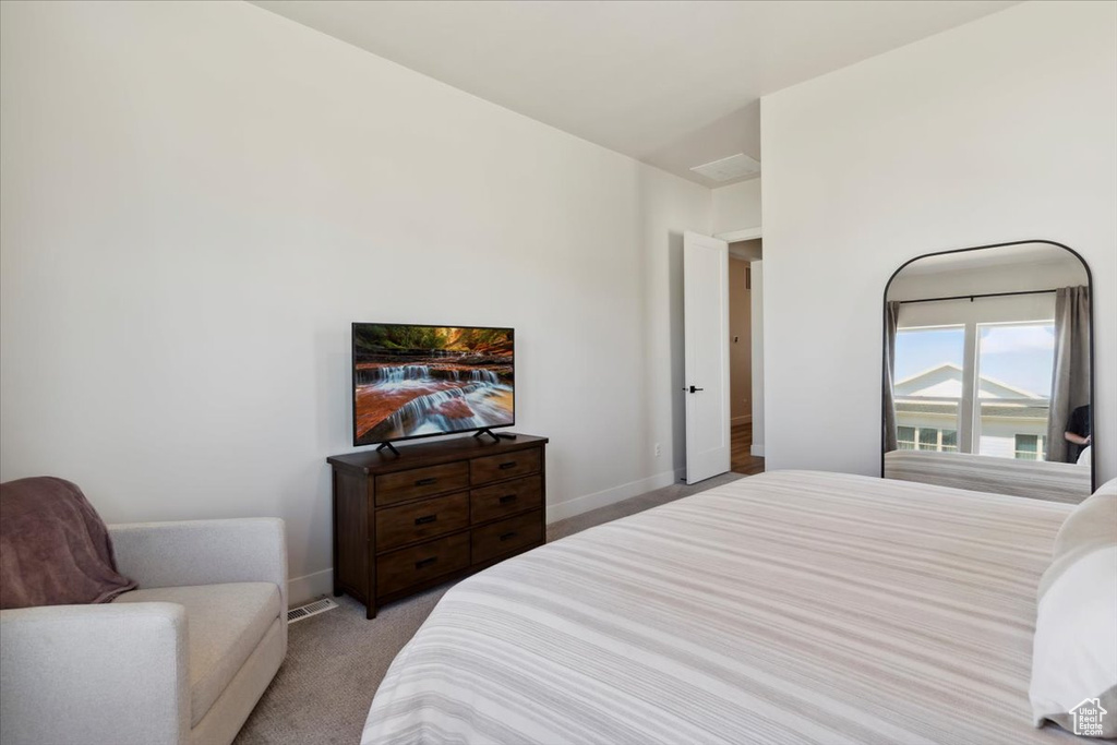 Bedroom featuring light carpet and baseboards