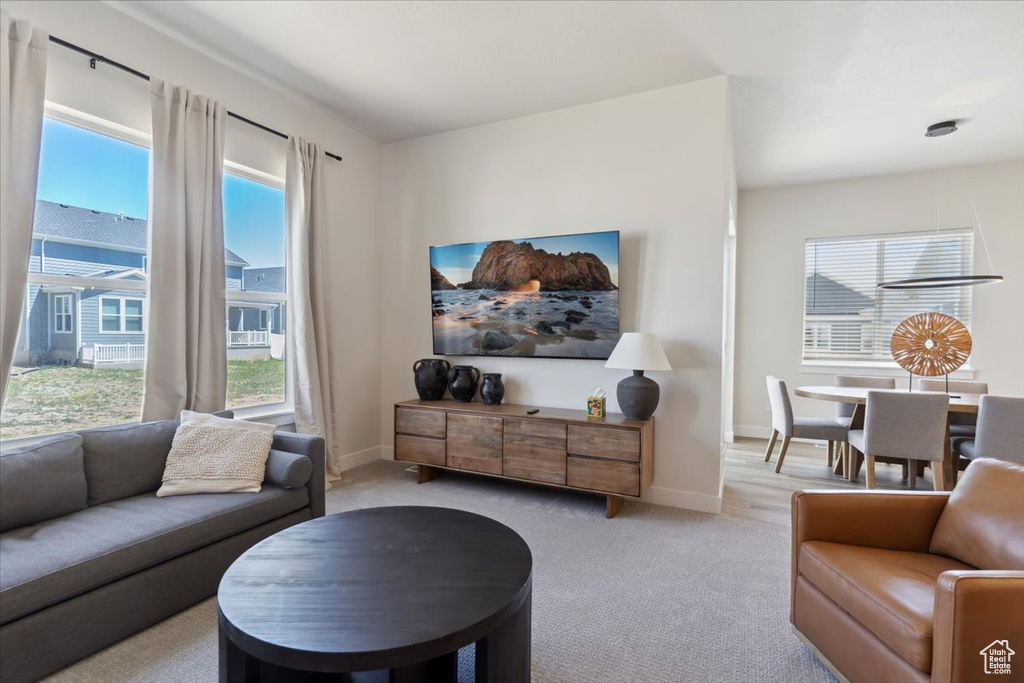 Living room with plenty of natural light, light carpet, and baseboards