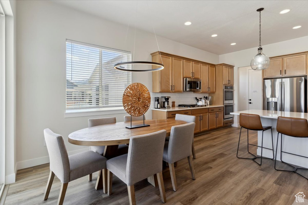 Dining area featuring recessed lighting, light wood-style floors, and baseboards