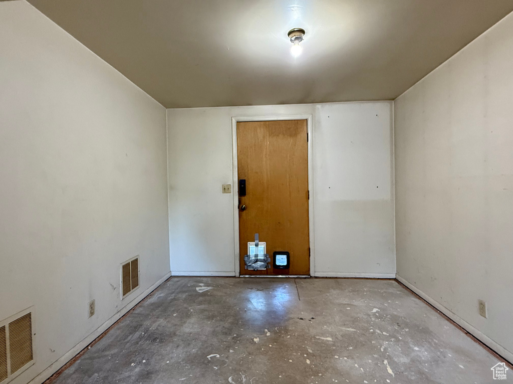 Empty room with unfinished concrete floors and baseboards