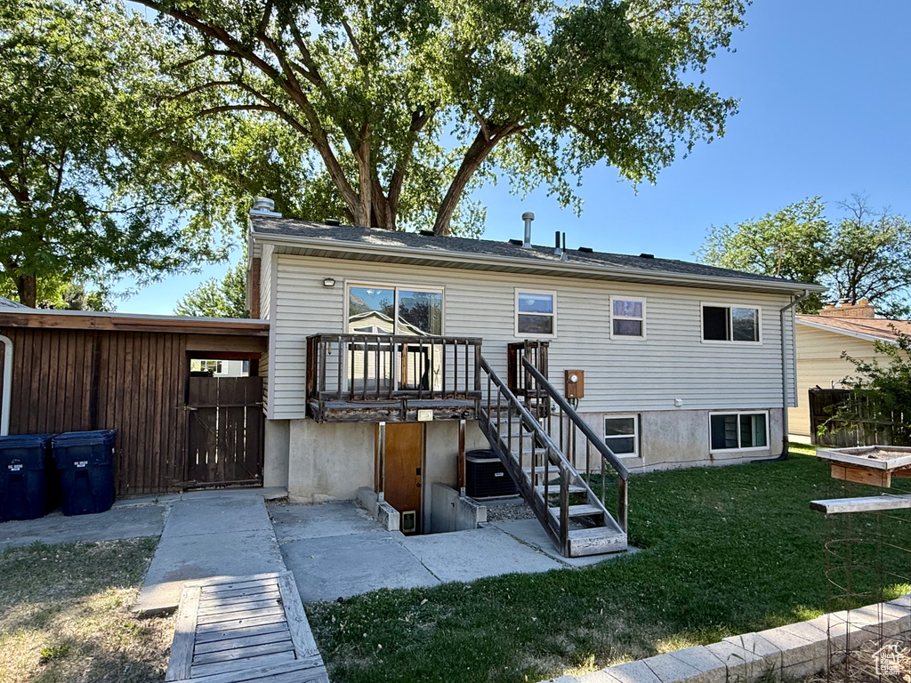 Back of property with a yard and cooling unit