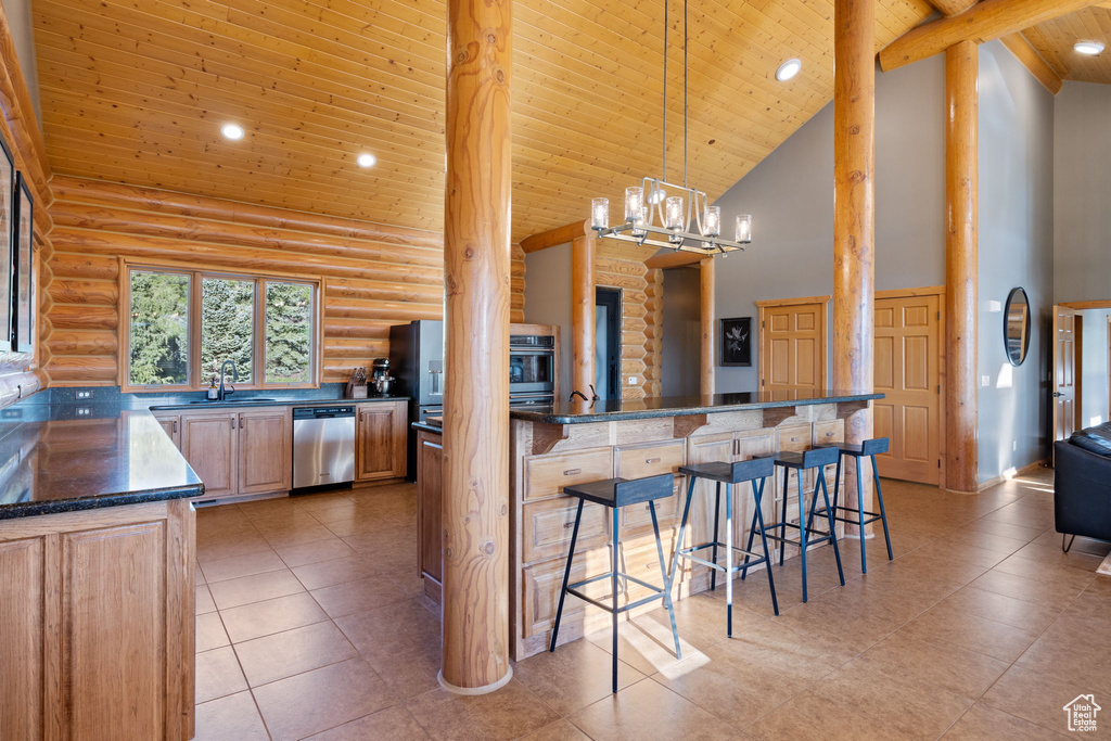 Kitchen featuring rustic walls, high vaulted ceiling, wooden ceiling with exposed beams, dishwasher, and a breakfast bar