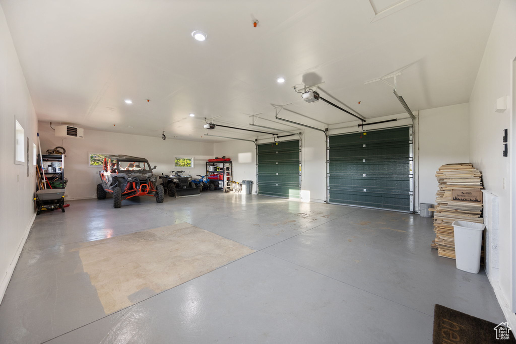 Garage featuring a garage door opener, recessed lighting, and baseboards