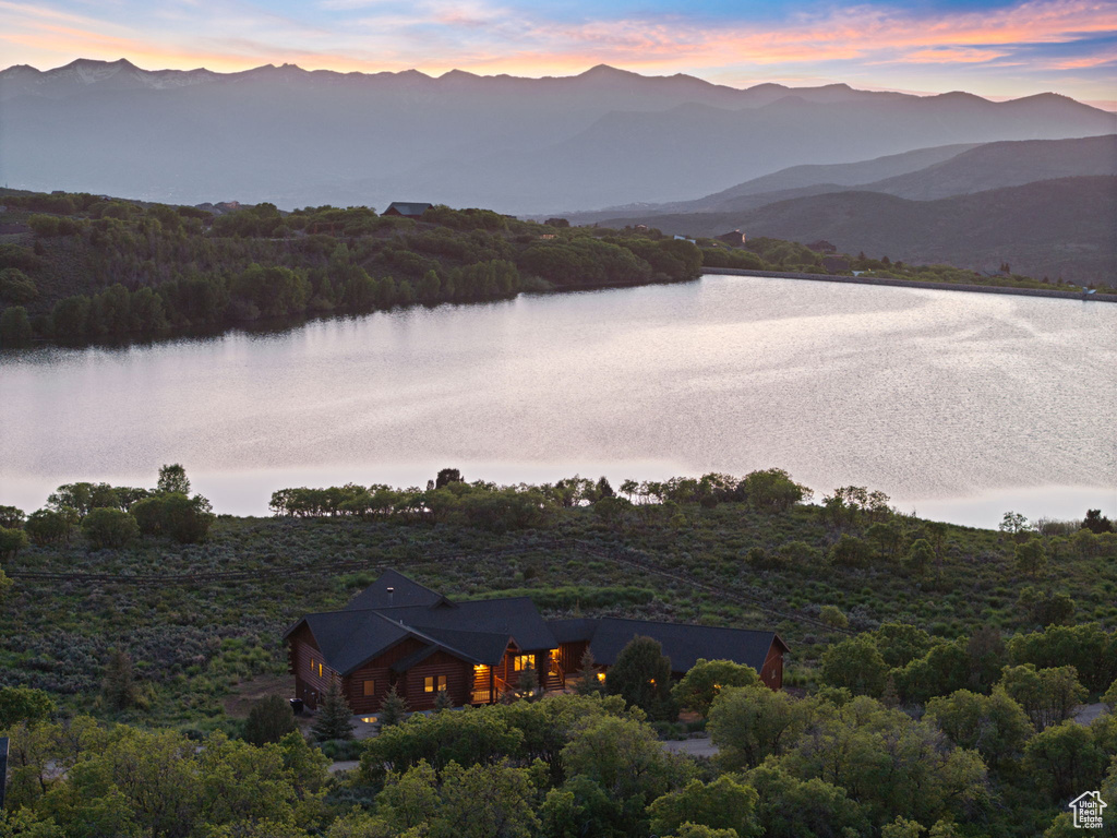 Water view featuring a mountainous background and a heavily wooded area