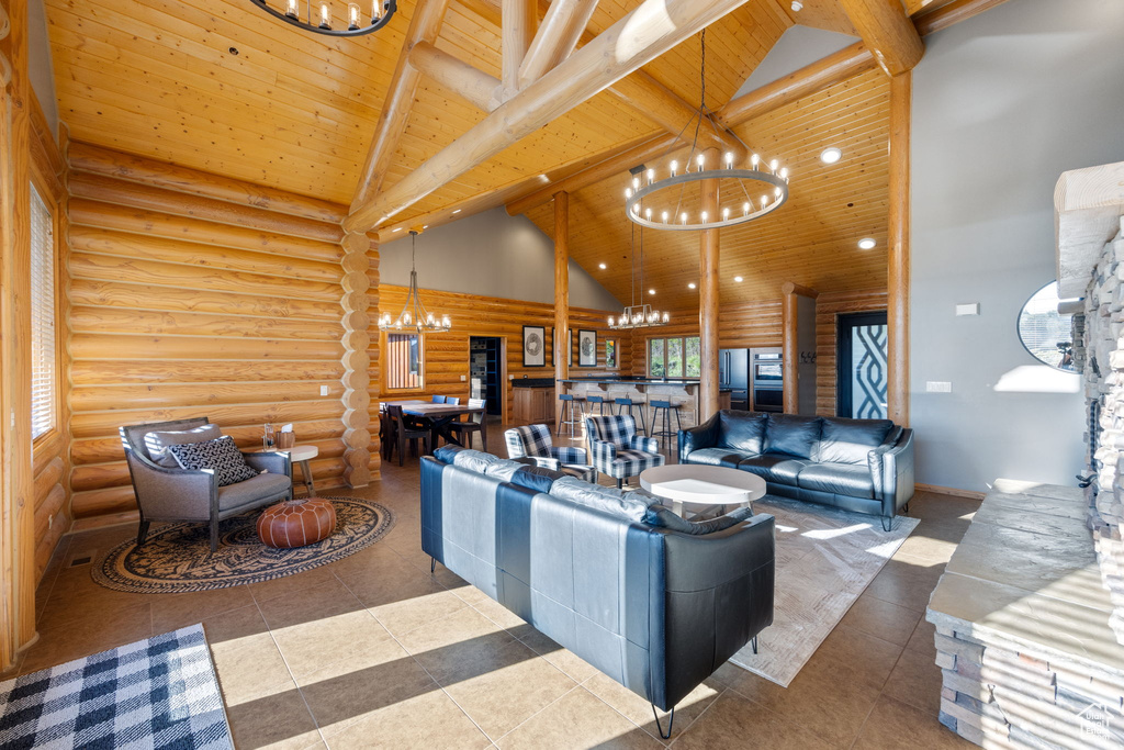 Living room with a chandelier, log walls, wood ceiling with exposed beams, high vaulted ceiling, and tile patterned floors