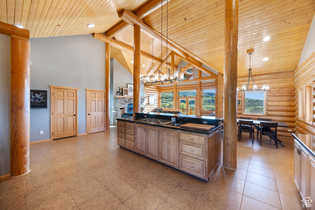 Kitchen featuring a chandelier, log walls, dark countertops, wood ceiling with exposed beams, and a sink