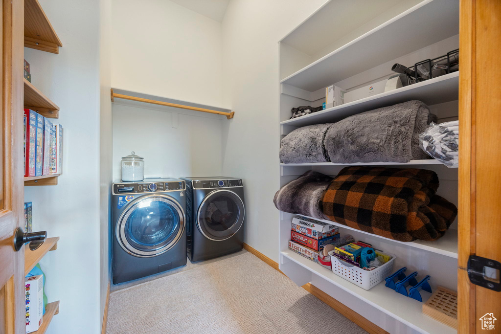 Laundry area featuring independent washer and dryer, carpet floors, and baseboards