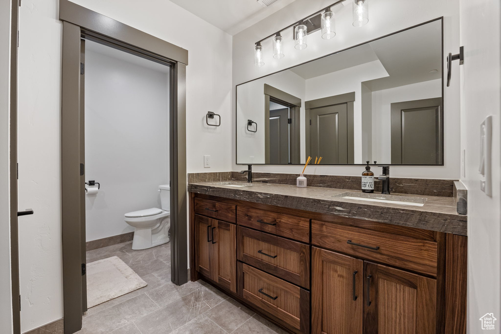 Bathroom with double vanity and toilet