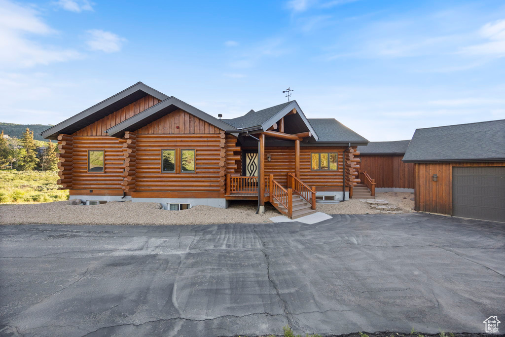 Log home with log exterior, an outdoor structure, and board and batten siding