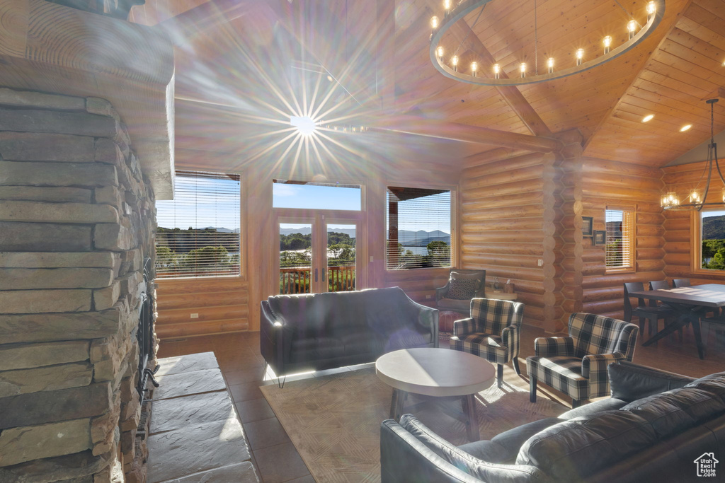 Tiled living area featuring a chandelier, rustic walls, wooden ceiling, plenty of natural light, and french doors