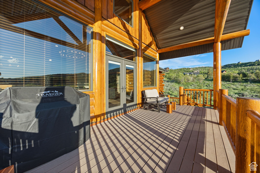 Wooden terrace with french doors and a grill