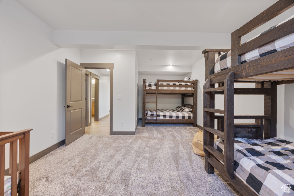 Bedroom featuring light colored carpet and baseboards