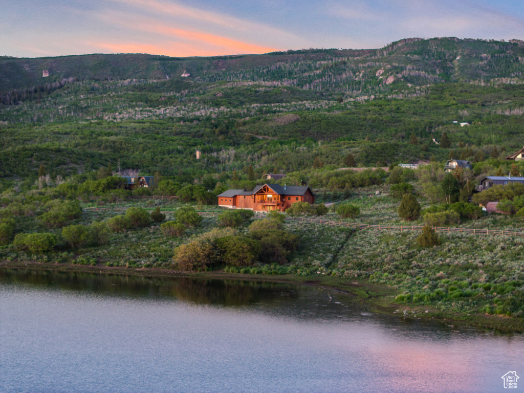 View of property location with a water and mountain view and a heavily wooded area