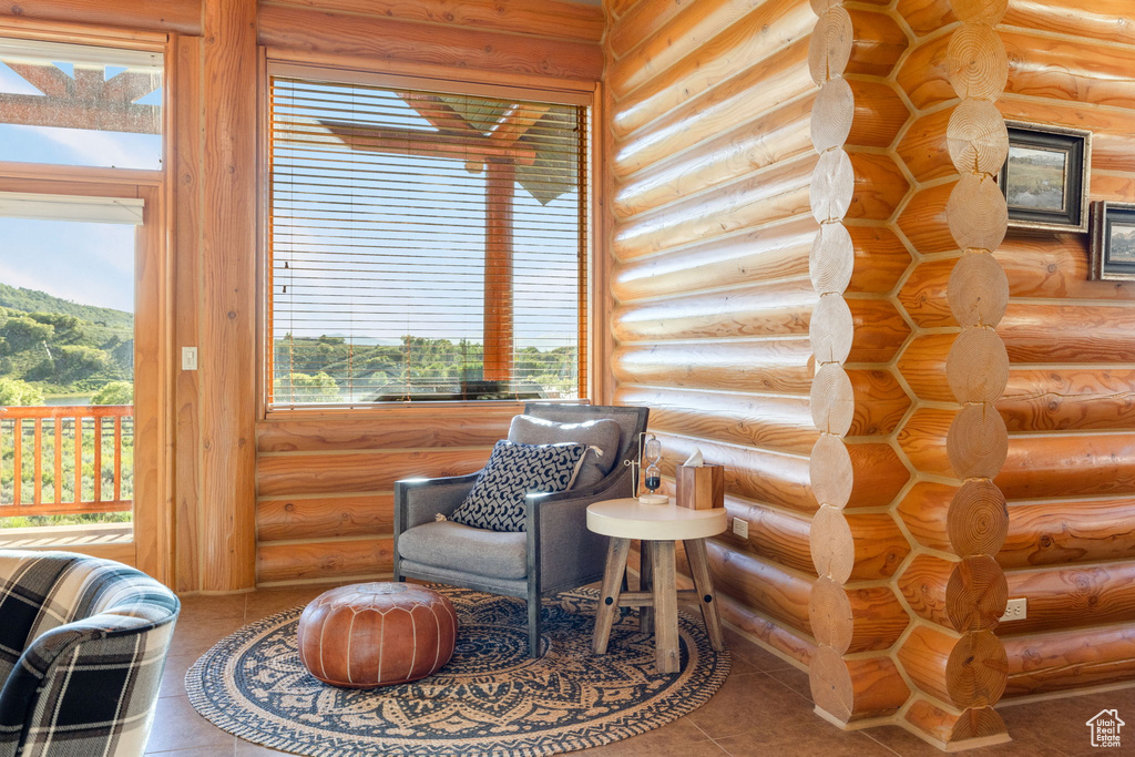 Living area featuring log walls and tile patterned flooring