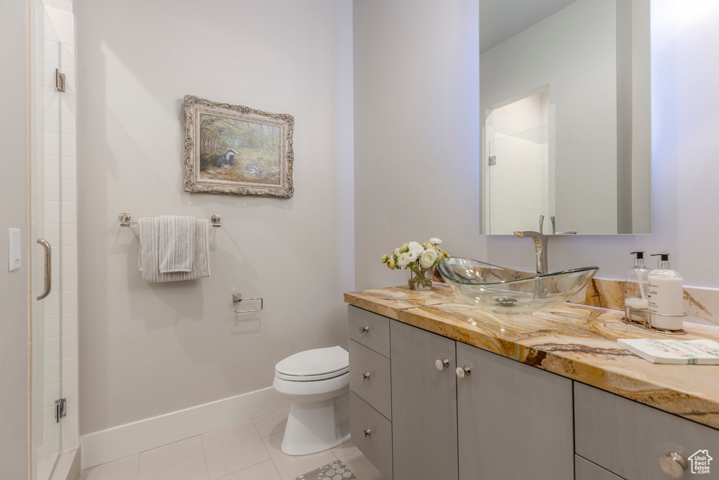 Bathroom featuring vanity, a stall shower, toilet, and tile patterned floors