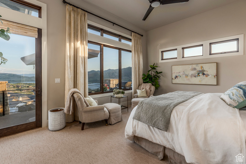Bedroom featuring access to outside, carpet floors, a mountain view, and multiple windows