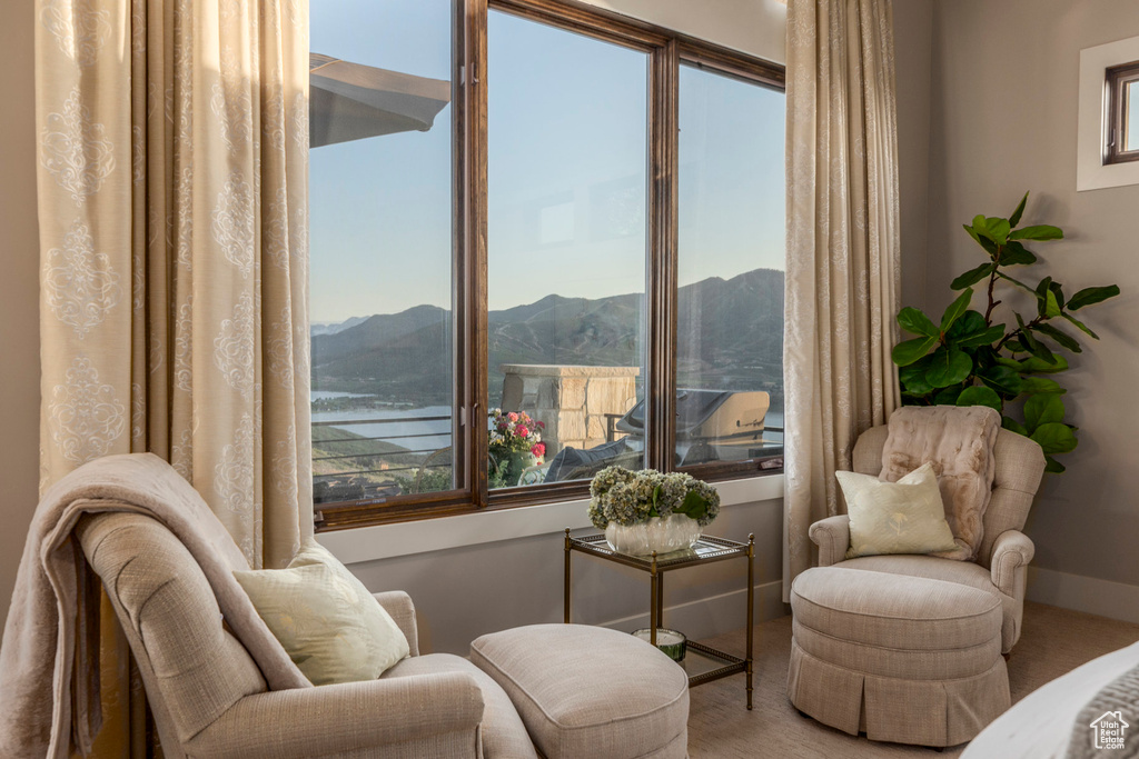 Sitting room featuring carpet, a mountain view, and healthy amount of natural light