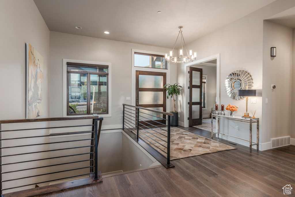 Interior space with a chandelier, wood finished floors, recessed lighting, and baseboards