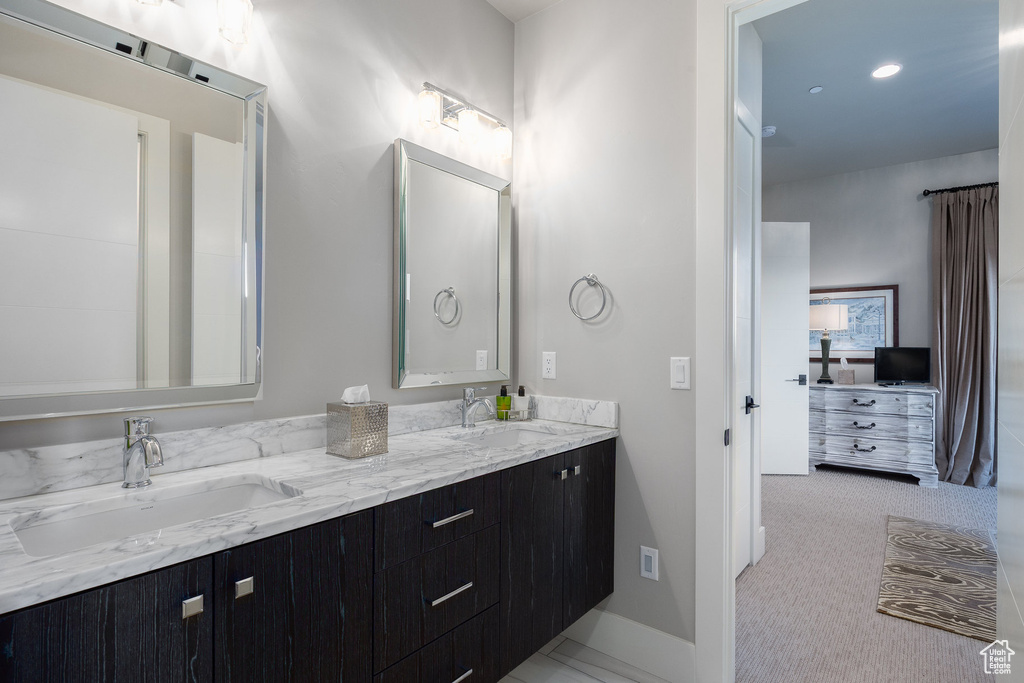 Full bath featuring double vanity and baseboards