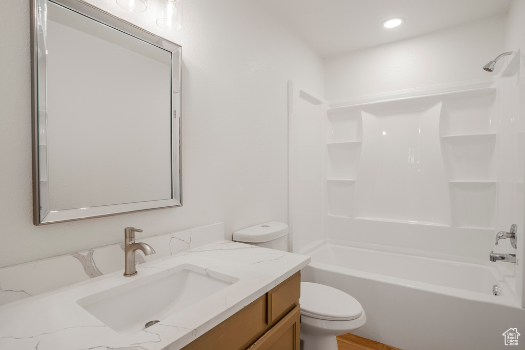 Bathroom with toilet, vanity, and tub / shower combination