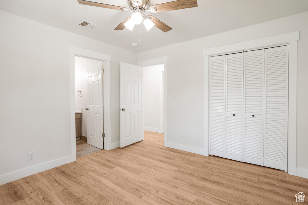 Unfurnished bedroom with light wood finished floors, baseboards, and a closet