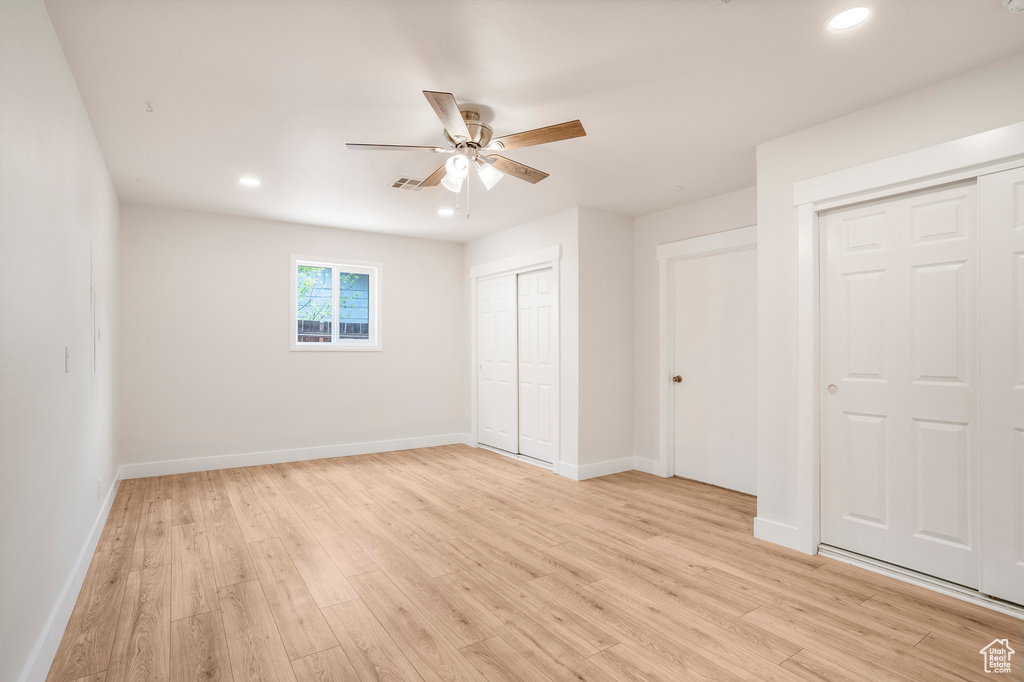 Unfurnished bedroom with multiple closets, light wood-type flooring, baseboards, recessed lighting, and ceiling fan