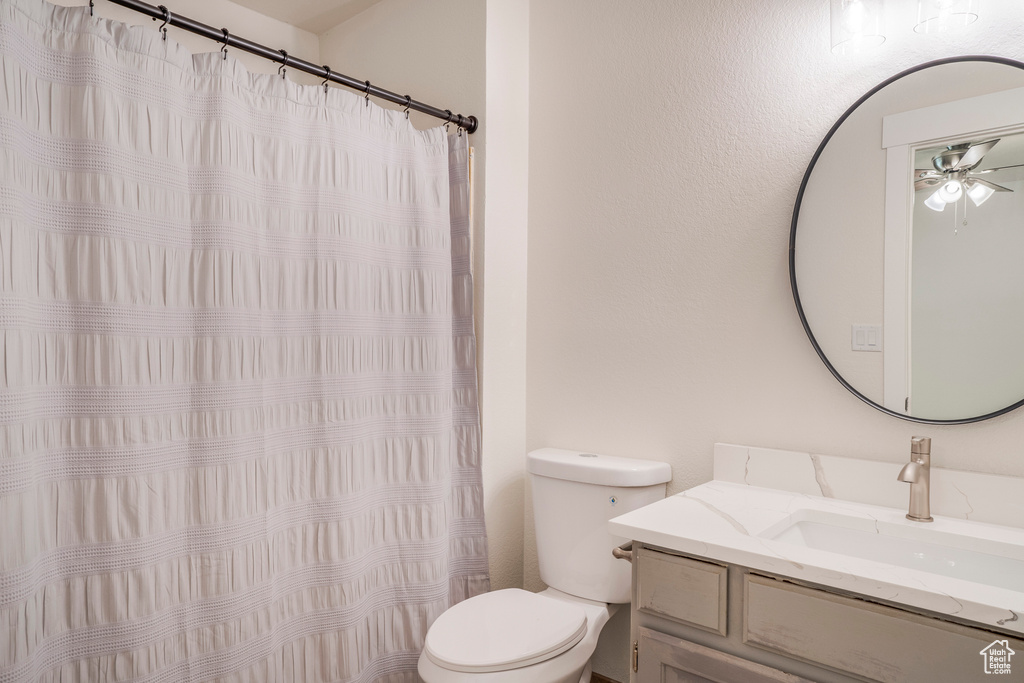 Full bath with toilet, ceiling fan, vanity, and a shower with curtain