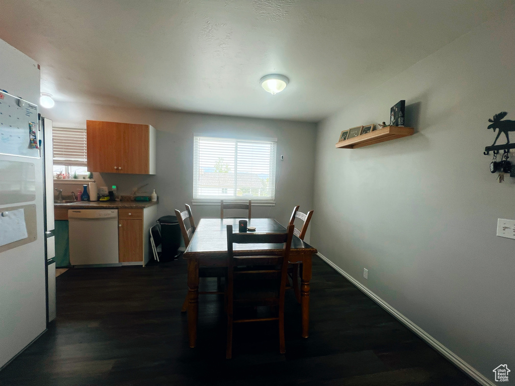 Dining room with healthy amount of natural light, dark wood-style flooring, and baseboards