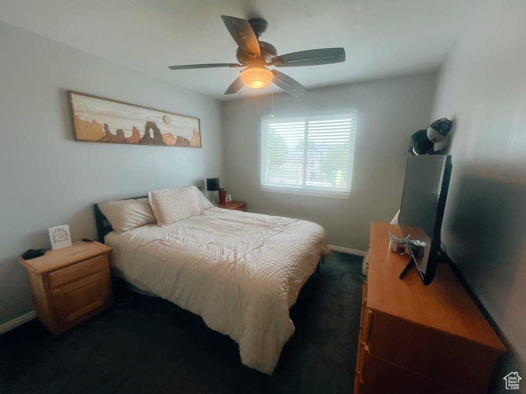 Carpeted bedroom with baseboards and a ceiling fan