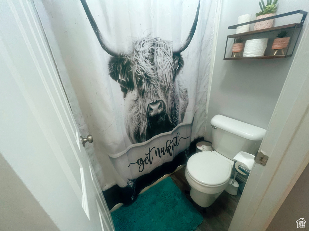 Full bath with toilet and wood finished floors
