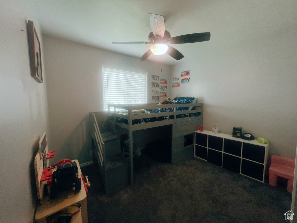 Bedroom with dark colored carpet and ceiling fan