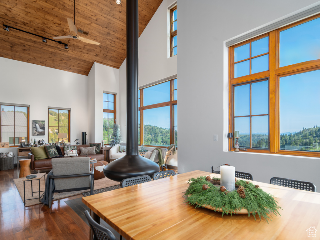 Dining space with high vaulted ceiling, dark wood finished floors, and wood ceiling
