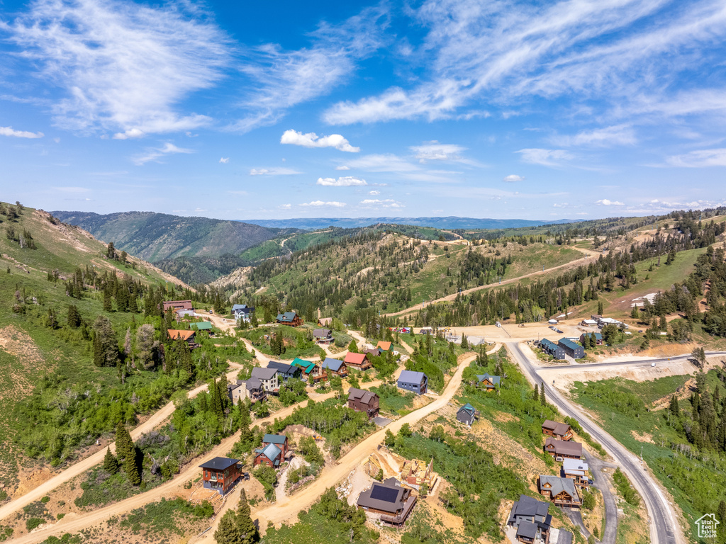 Aerial view of property and surrounding area with a mountain backdrop