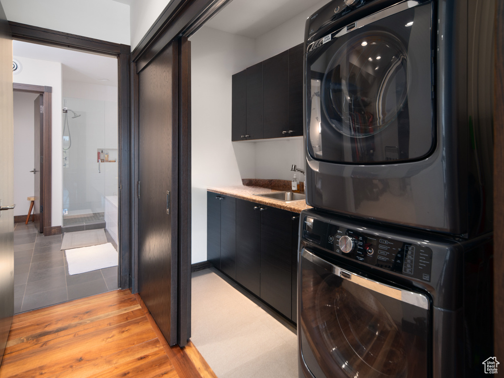 Laundry room featuring stacked washer and clothes dryer and tile patterned flooring