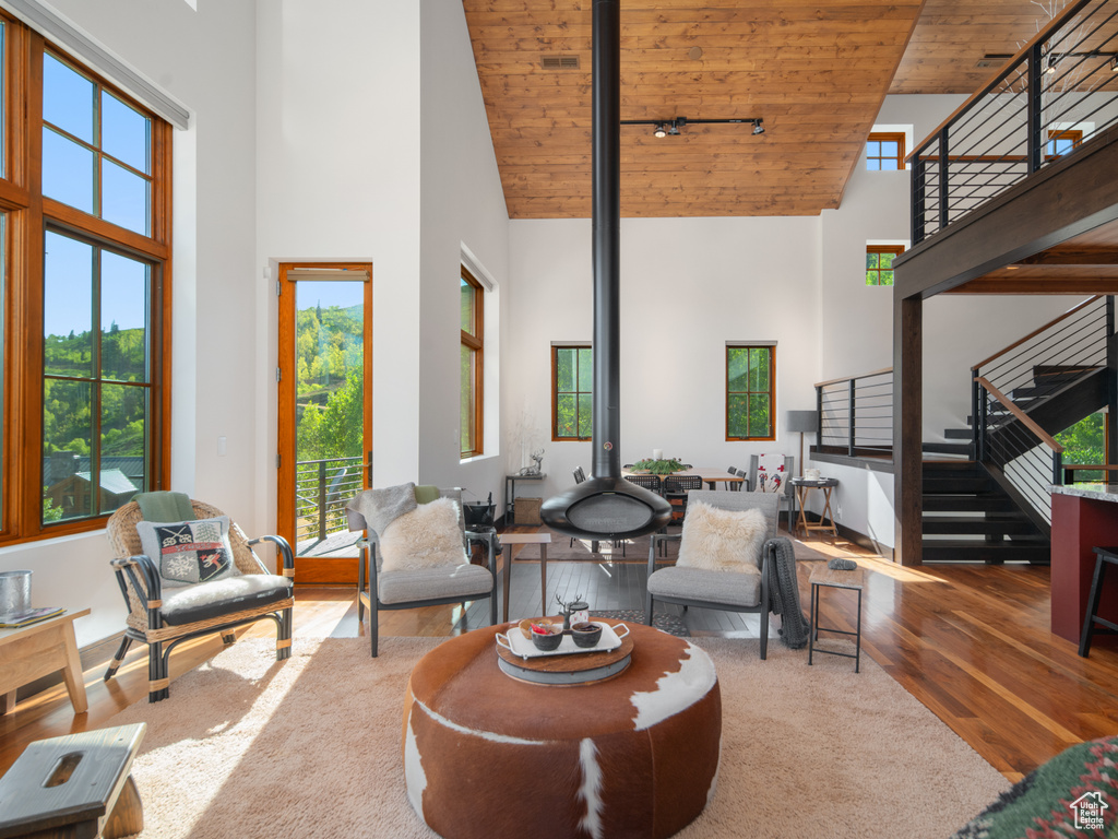 Living area featuring wooden ceiling, high vaulted ceiling, hardwood / wood-style flooring, stairs, and healthy amount of natural light