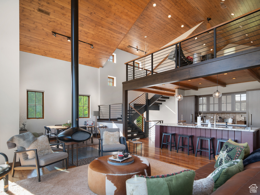Living area with high vaulted ceiling, stairway, wood finished floors, wood ceiling, and recessed lighting