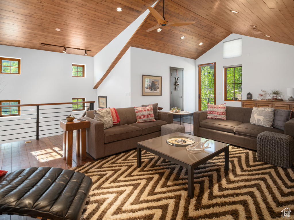 Living room featuring wooden ceiling, rail lighting, vaulted ceiling, ceiling fan, and wood-type flooring