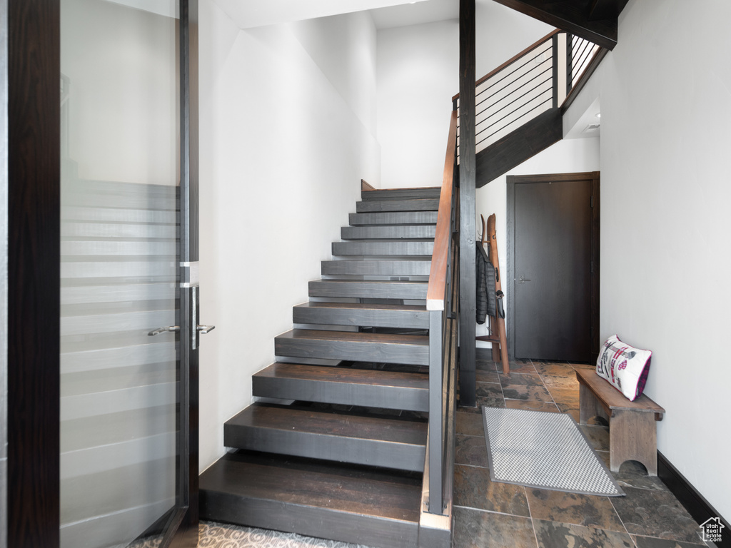 Staircase with stone tile flooring and baseboards
