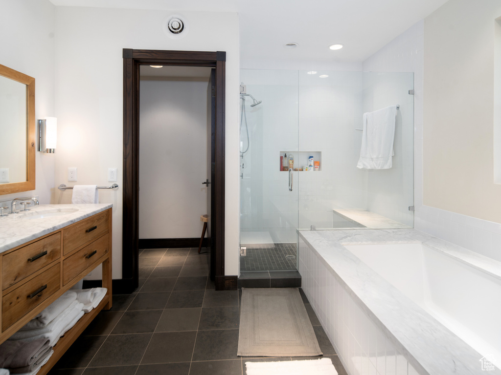 Bathroom with a stall shower, tile patterned flooring, a garden tub, vanity, and recessed lighting