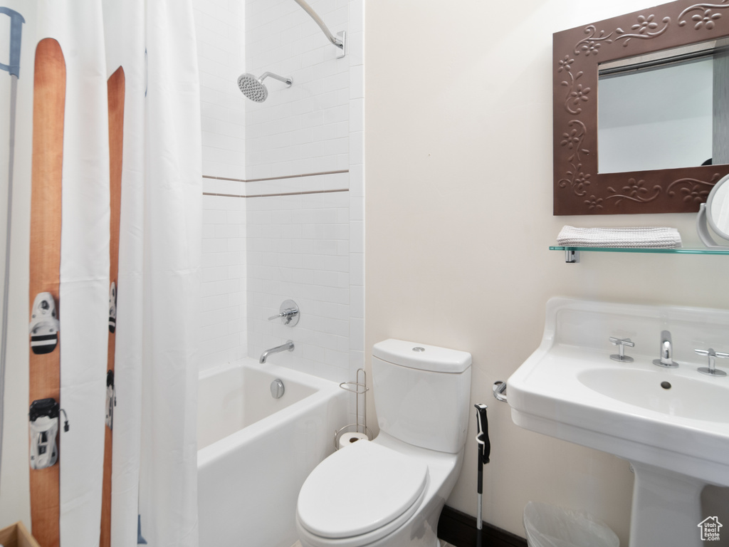 Full bathroom with shower / tub combo with curtain and toilet