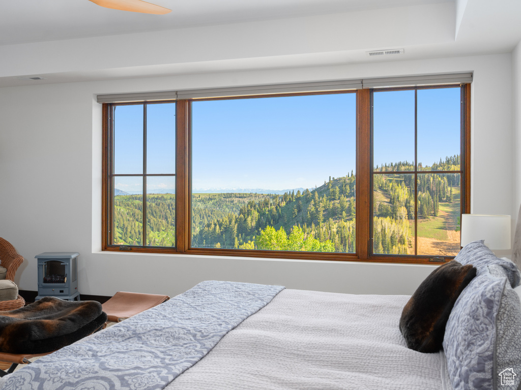 Bedroom with multiple windows and a wood stove