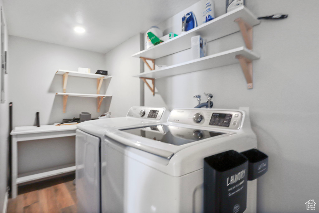 Washroom with separate washer and dryer and dark wood-style floors