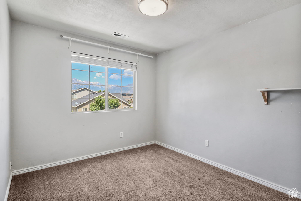 Carpeted spare room with baseboards
