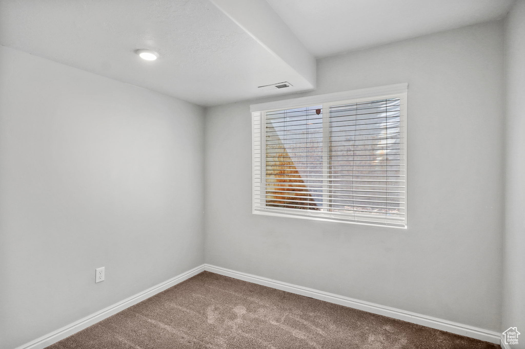 Carpeted empty room featuring baseboards
