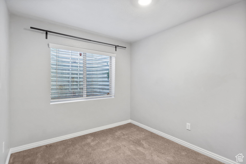 Carpeted empty room featuring baseboards