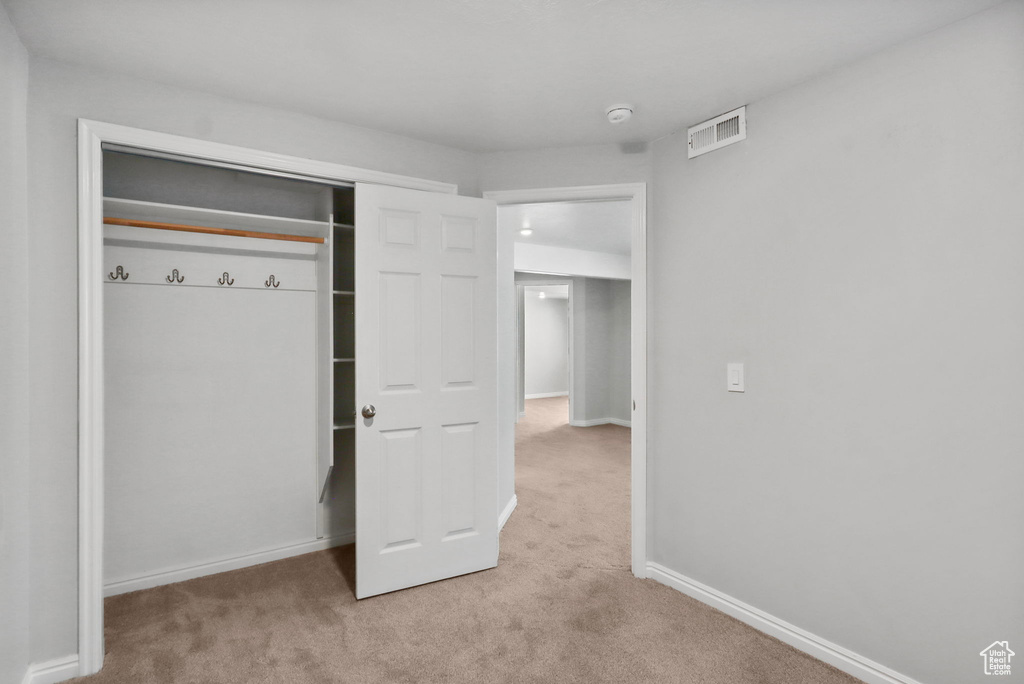 Unfurnished bedroom with carpet, baseboards, and a closet