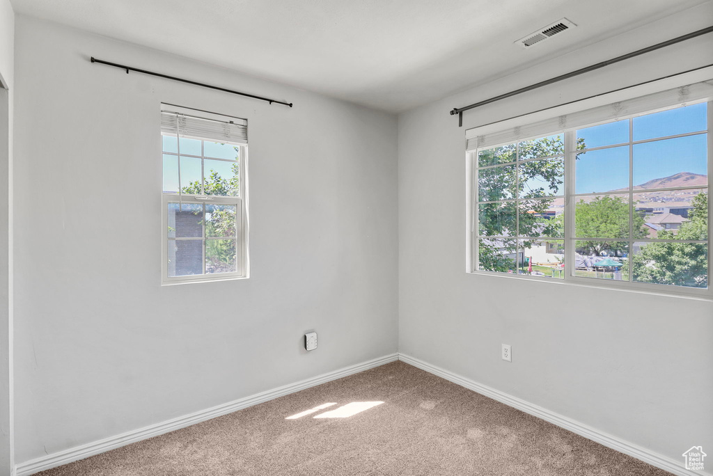 Spare room featuring carpet and baseboards