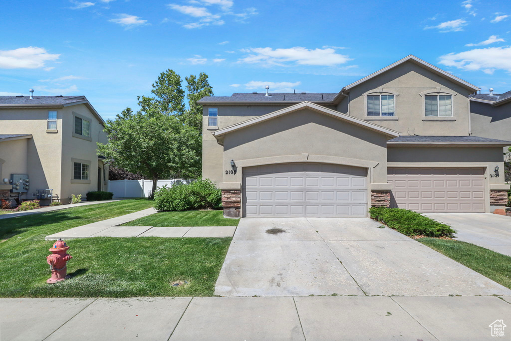 Traditional-style home with stucco siding, a garage, and concrete driveway