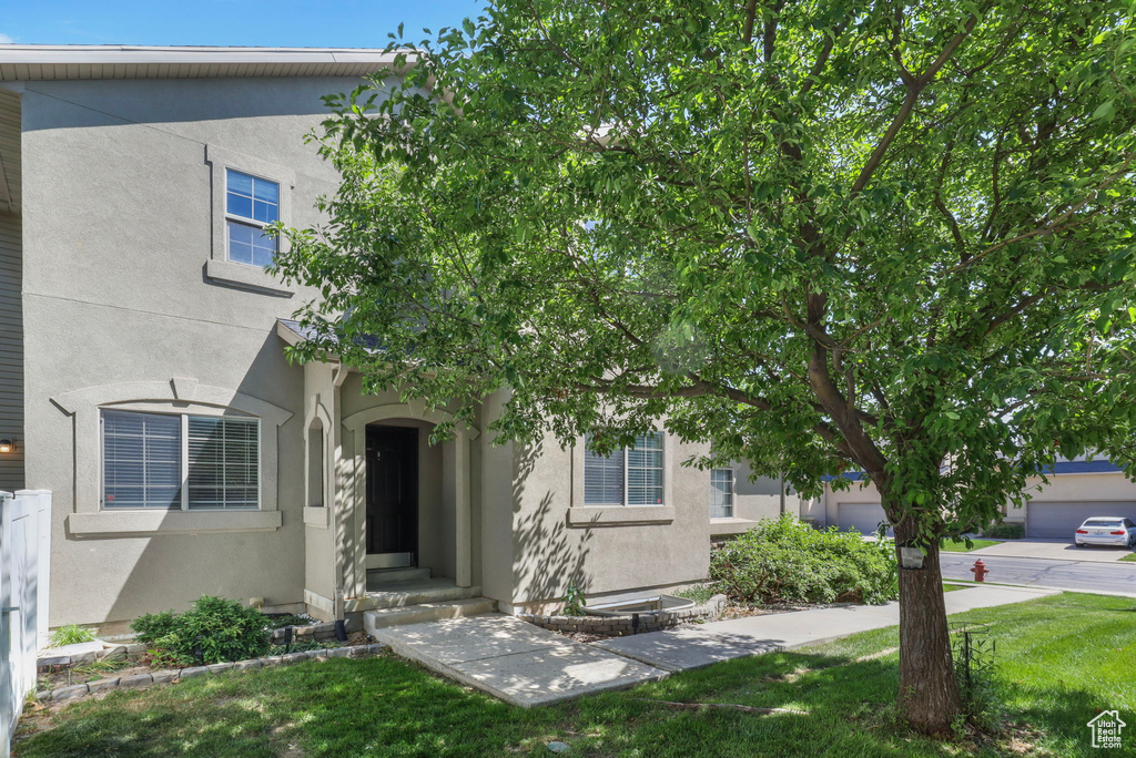View of front of property featuring stucco siding and a front lawn